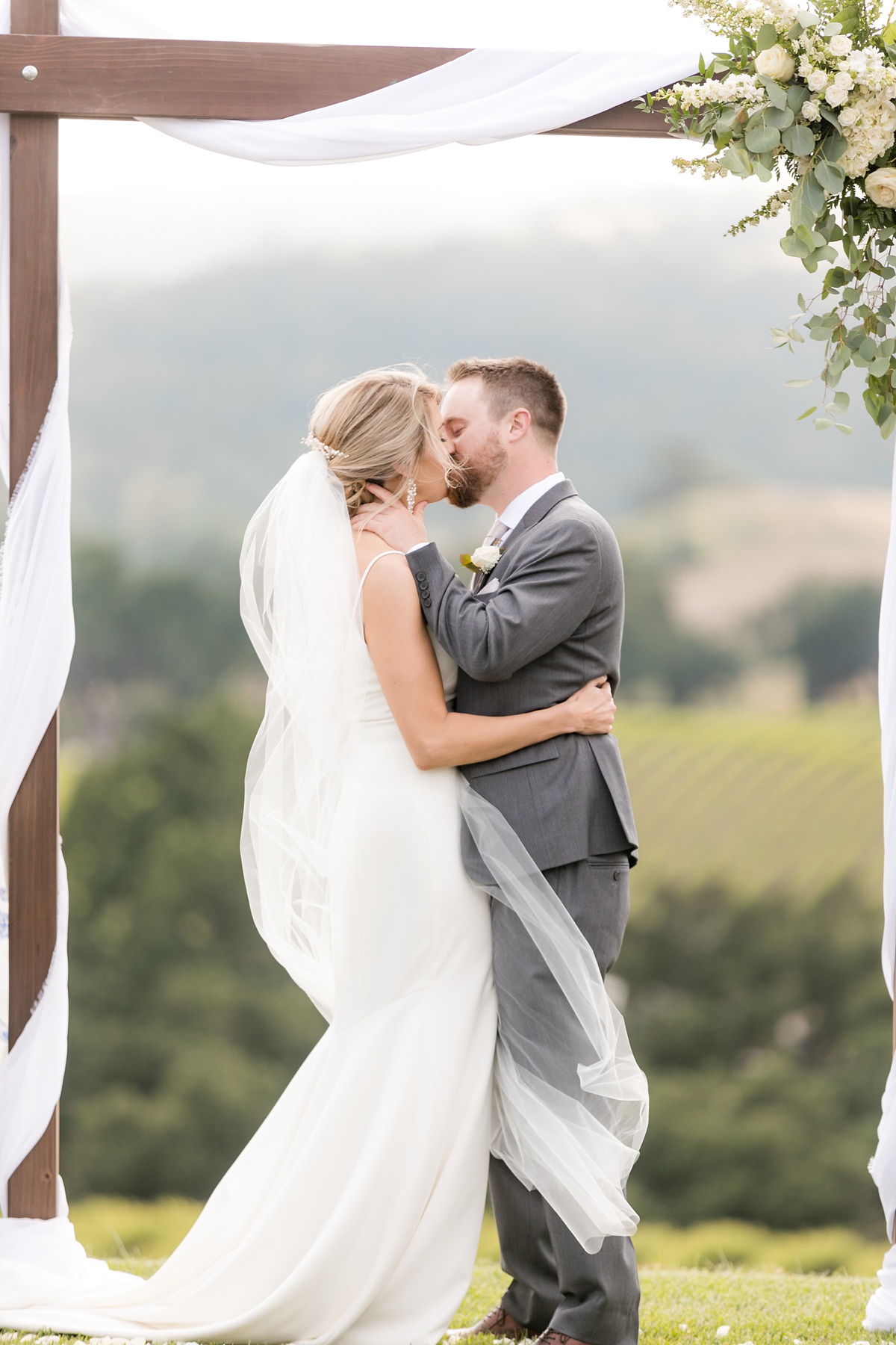 Bride and groom first kiss at Hilltop winery wedding in paso robles, ca