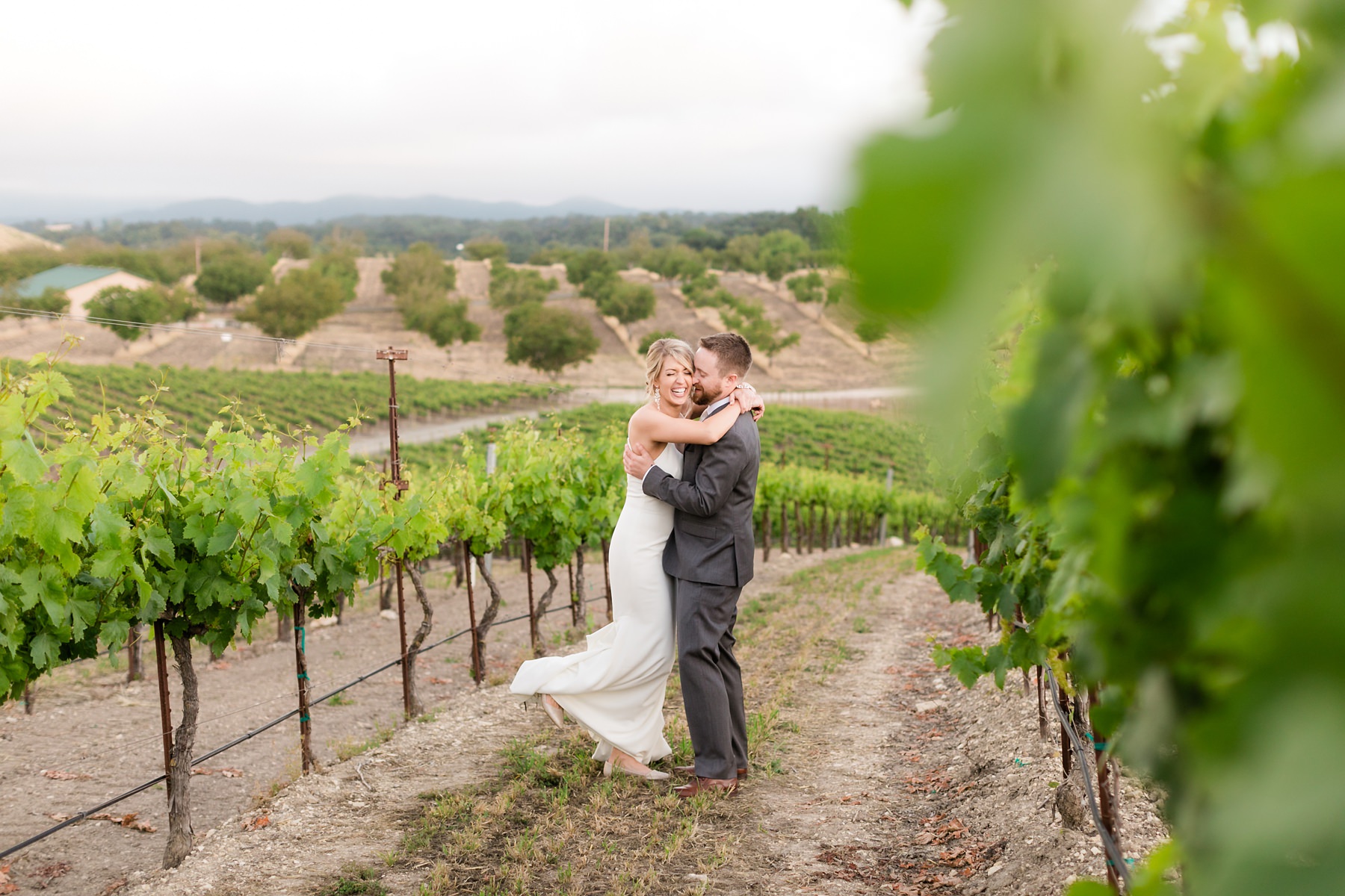 Bride and groom laughing and embracing at this Foggy hilltop winery Wedding in Paso Robles, CA. Opolo Vineyard