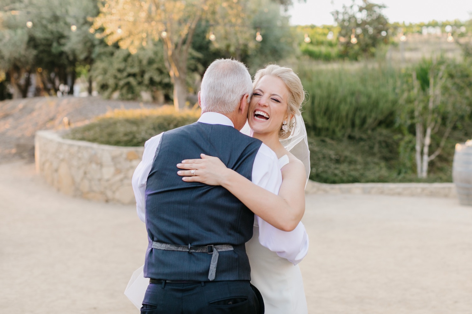 bride laughing and embracing her father during their father daughter dance at terra mia wedding