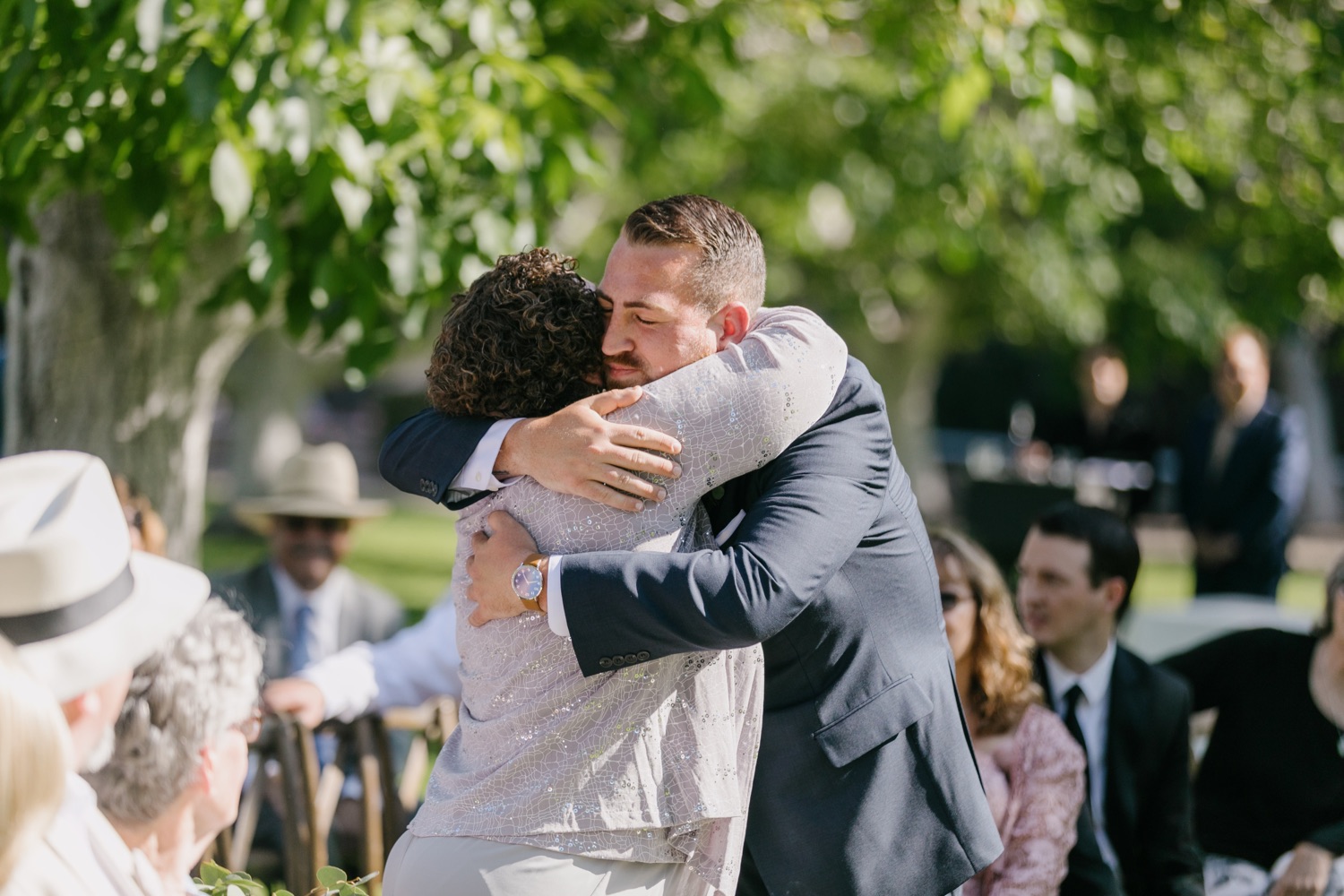 Groom embracing his mother after he walks down the aisle before the ceremony at Walnut grove