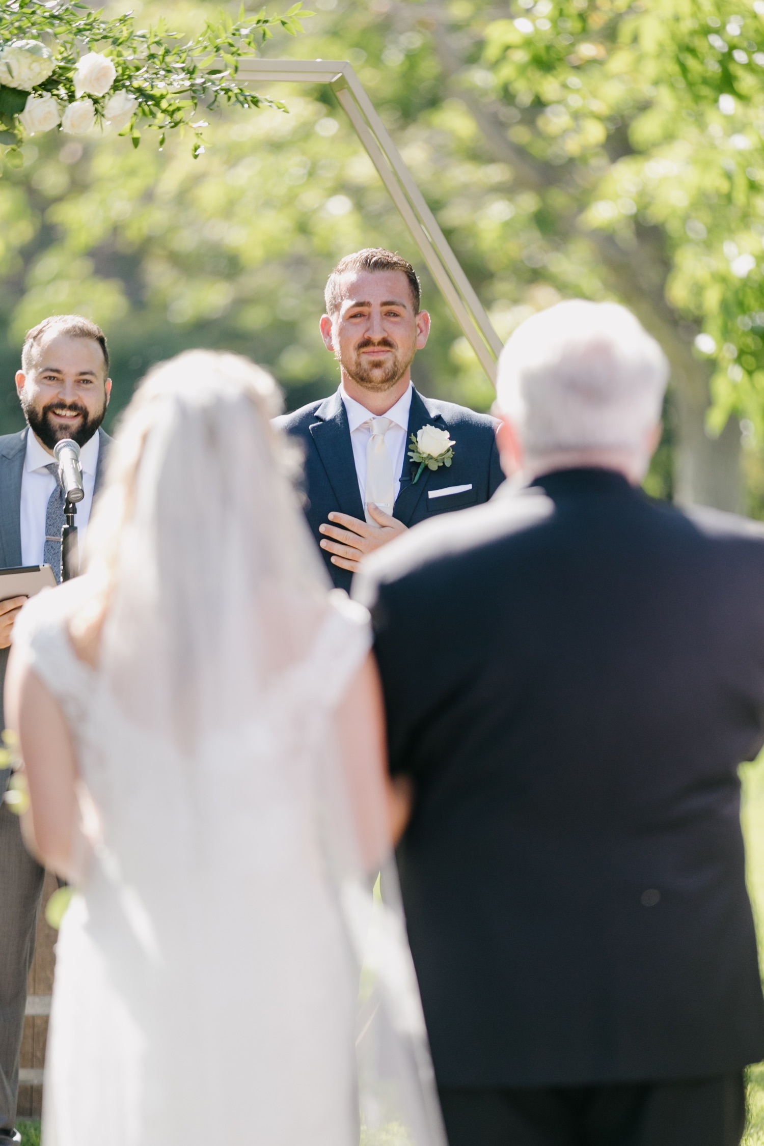 Groom getting emotional as he sees his bride walk down the aisle for the first time at walnut grove wedding ceremony. Sweetest first look