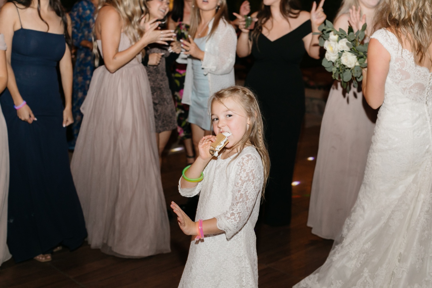 niece and flower girl eating s'mores on the dance floor