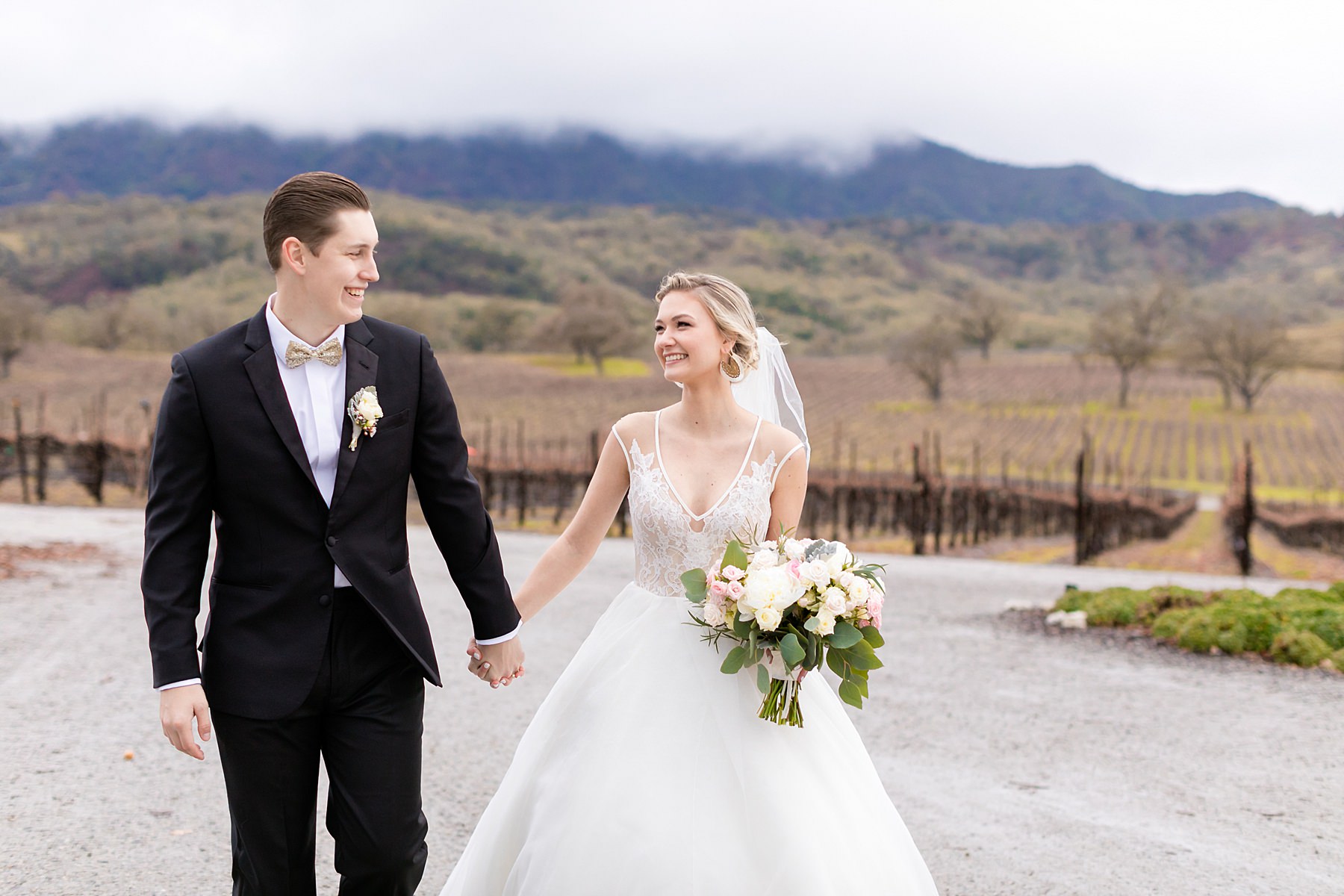 Smiling couple pose for photo on their rainy Oyster Ridge winery wedding day