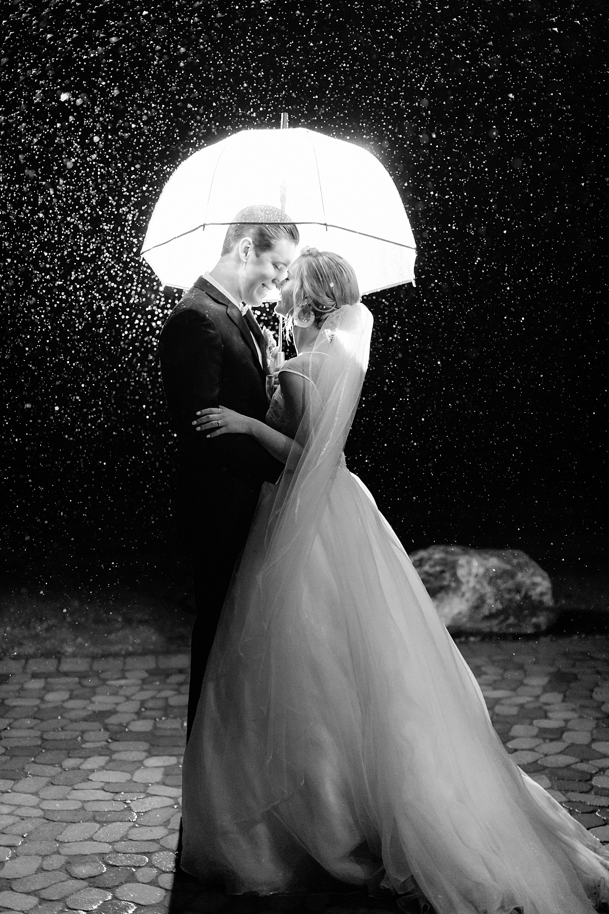 Oyster Ridge wedding photo of bride and groom in the rain at night by Tayler Enerle
