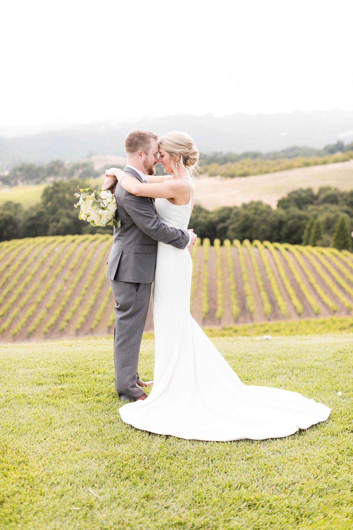Bride and groom embrace at hilltop winery wedding in paso robles california