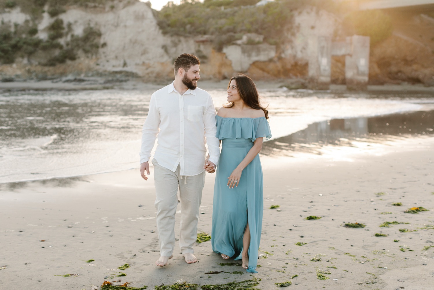 couples walking on the beach in Avila california for their engagement session