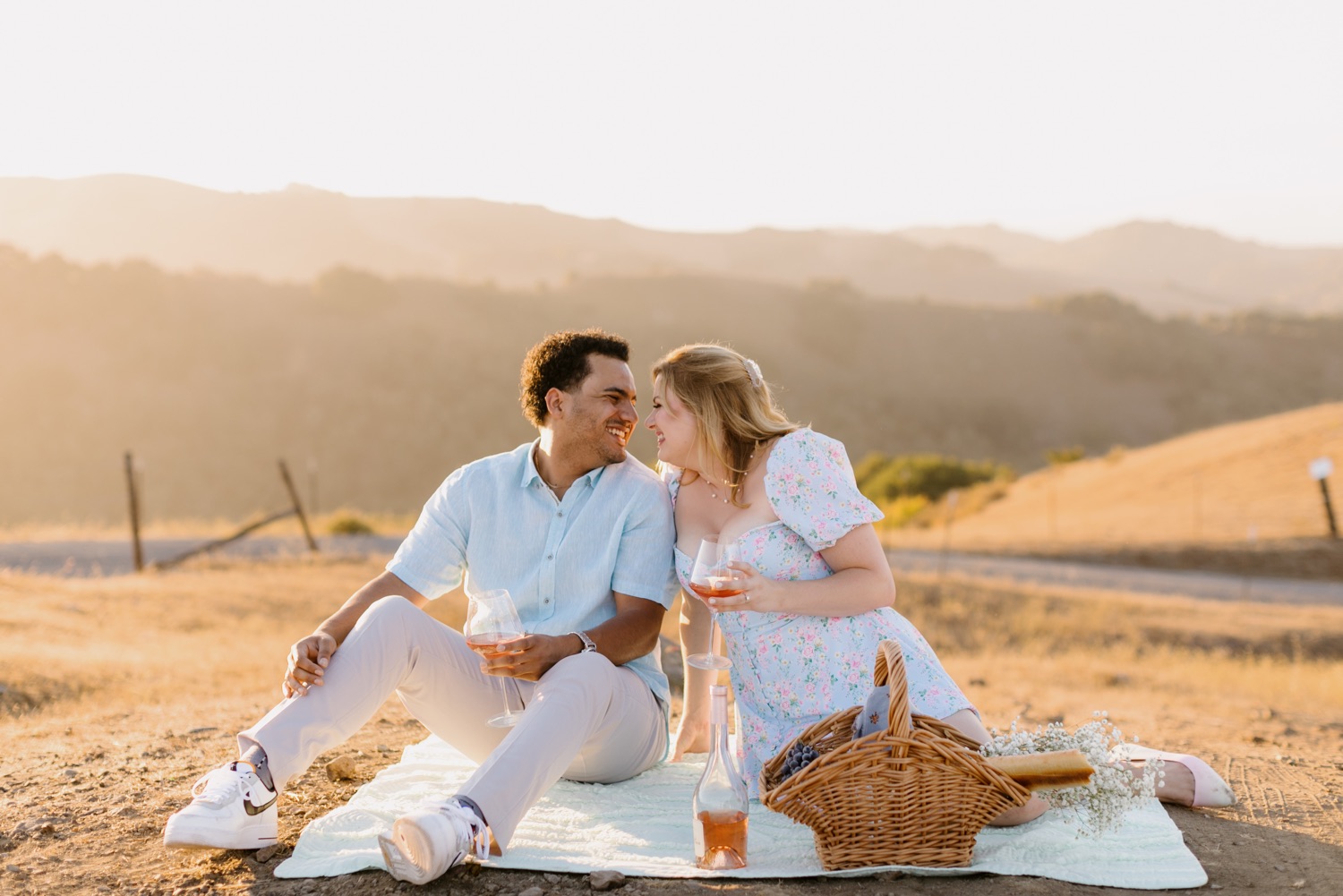 couple sitting at picnic and snuggling at san luis obispo engagement session