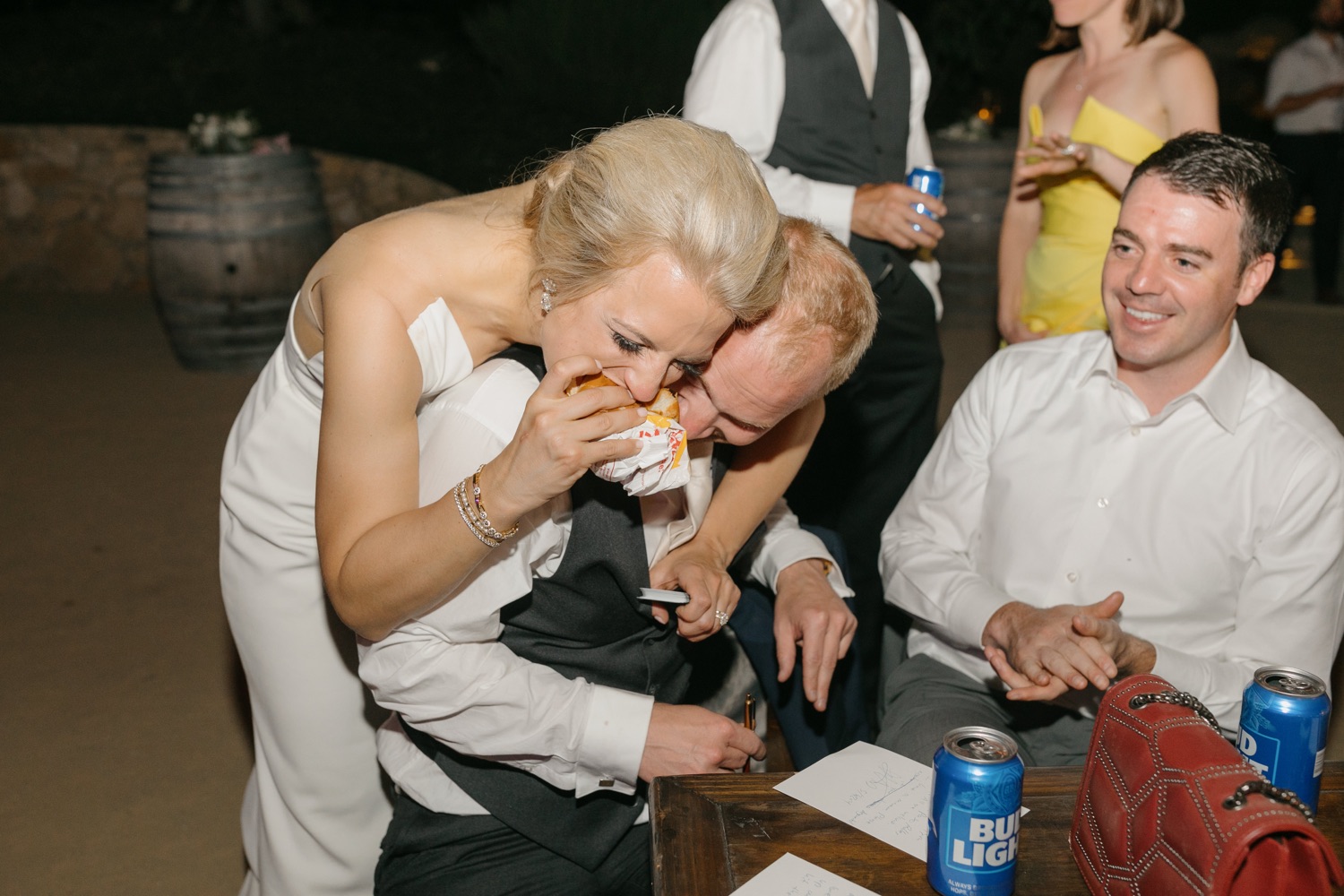 Bride eating in n out and embracing husband at her Terra Mia wedding reception