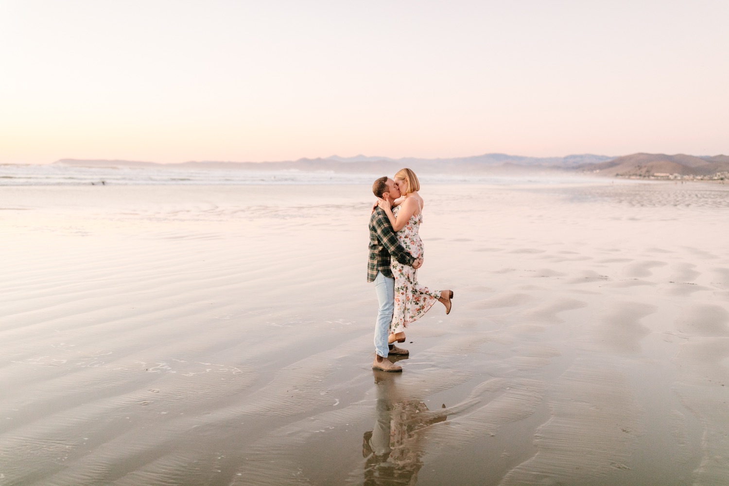 bride and groom kissing in front of Morro bay rock engagement session