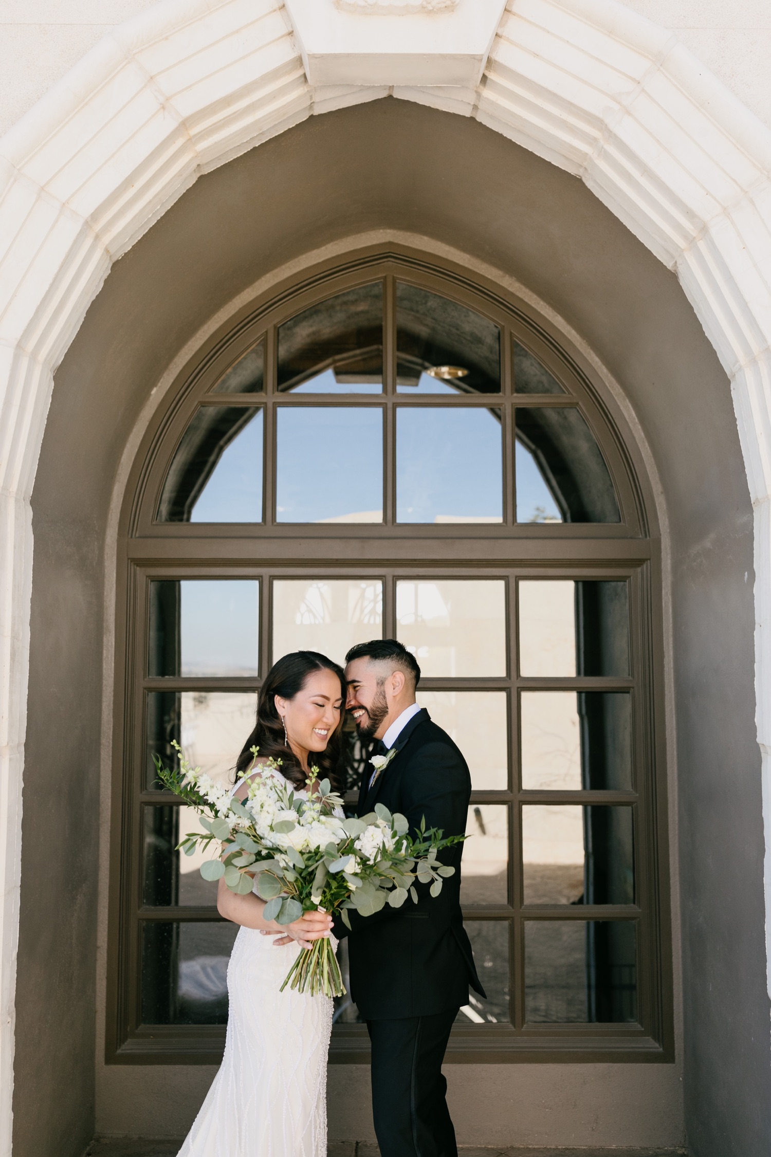 Bride and groom snuggling together on their wedding day at Tooth and nail winery in Paso robles, California. Photos by Tayler Enerle