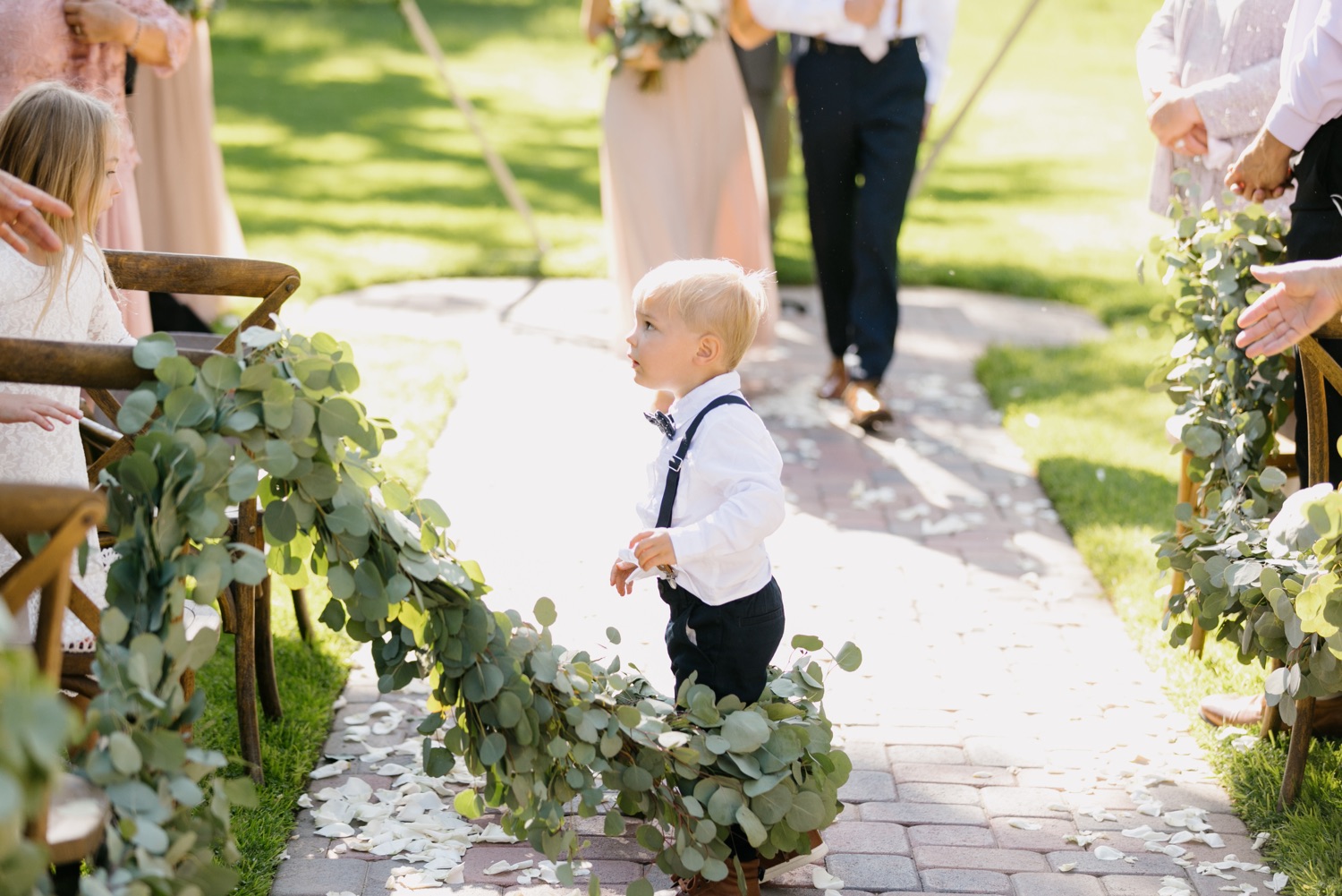 ring bearer in the middle of the aisle at ceremony