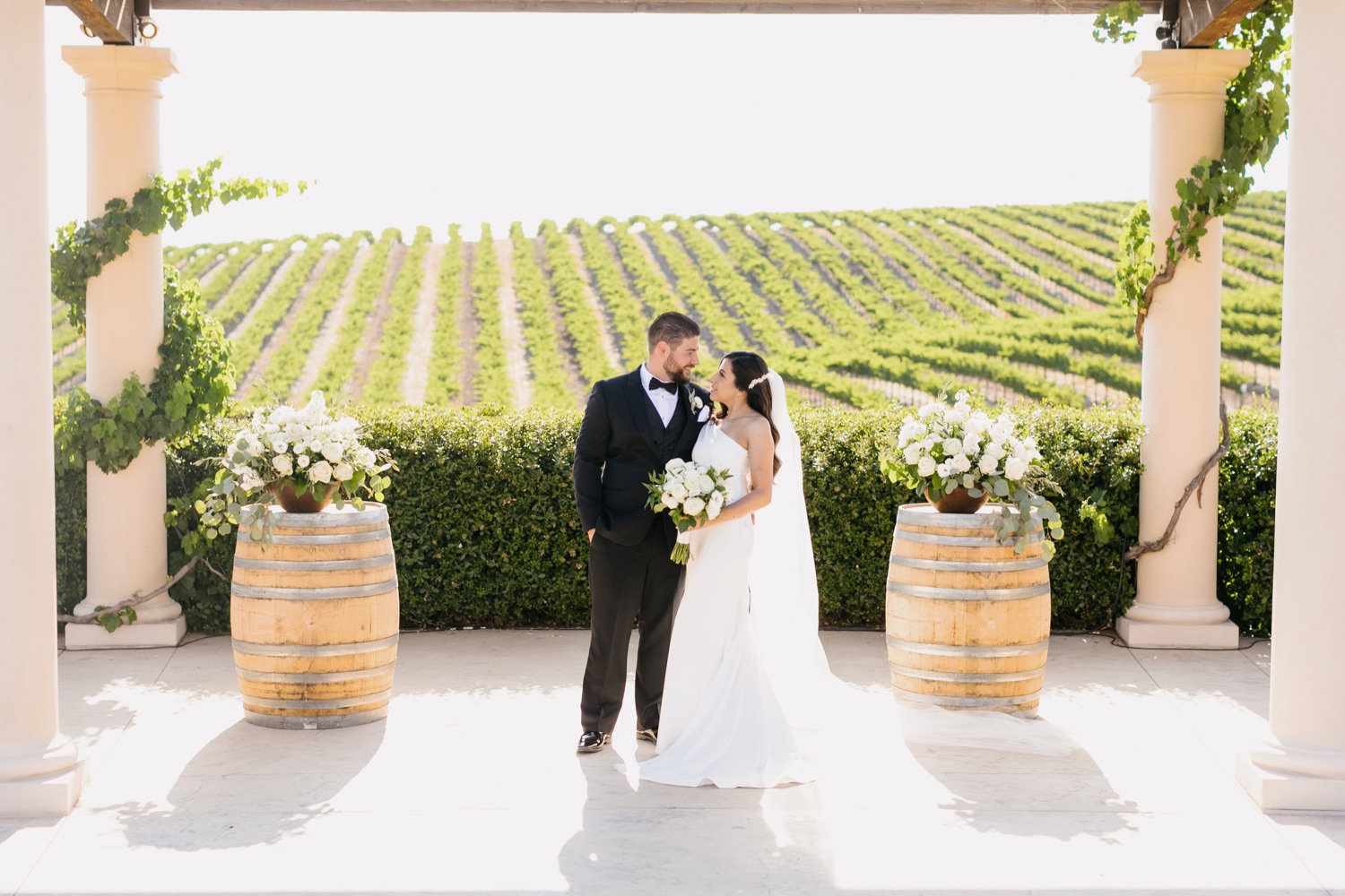 bride and groom smiling at each other during sunset photos at villa san juliette winery in paso robles