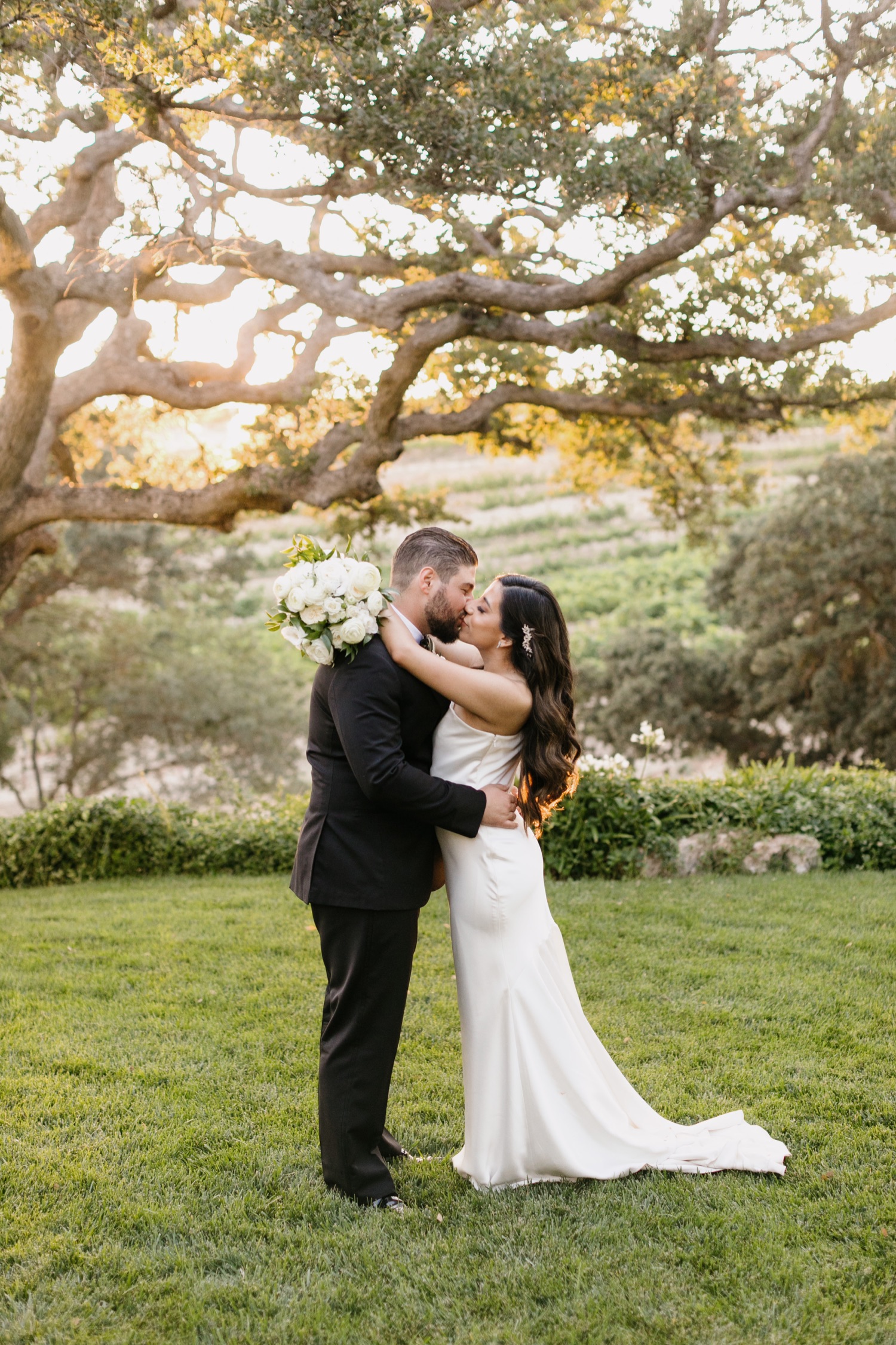 Bride and groom kissing during sunset photos at Villa San Juliette winery