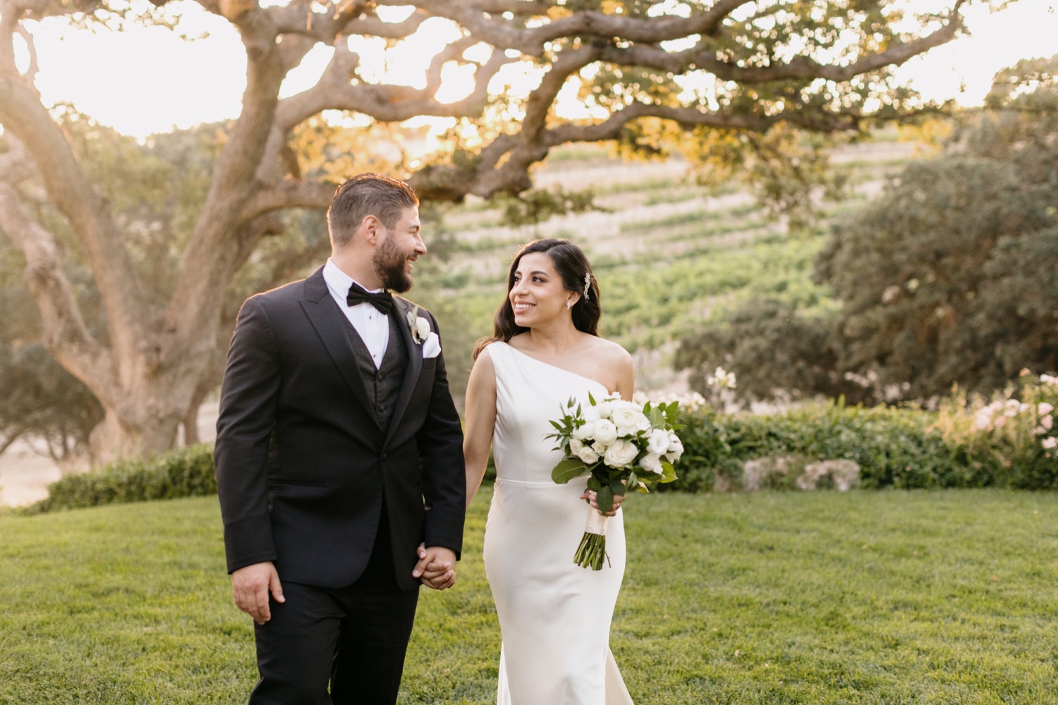 Bride and groom walking and smiling during sunset photos at Villa San Juliette winery