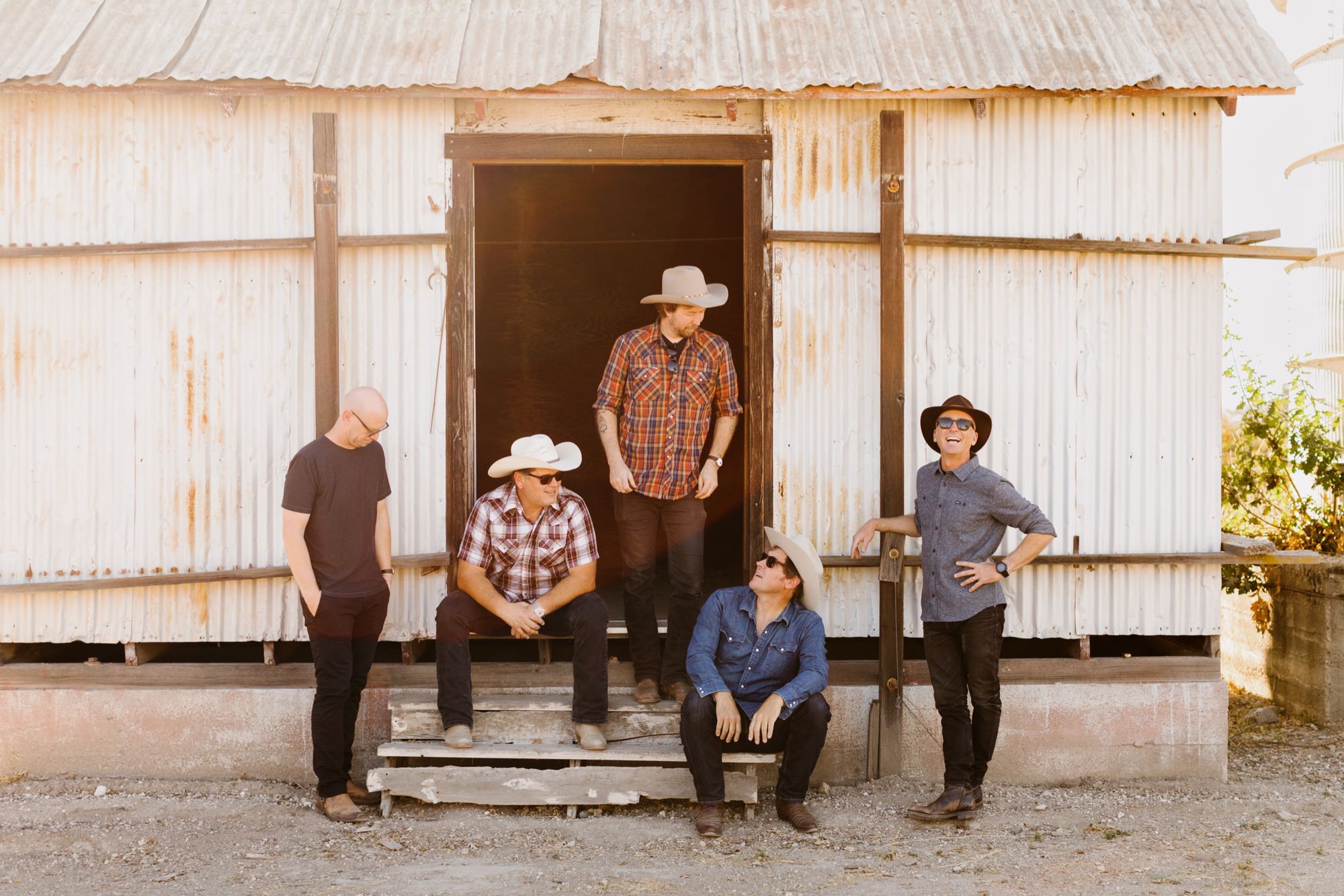 Shawn family clark band posing on an old barn shed at sunset