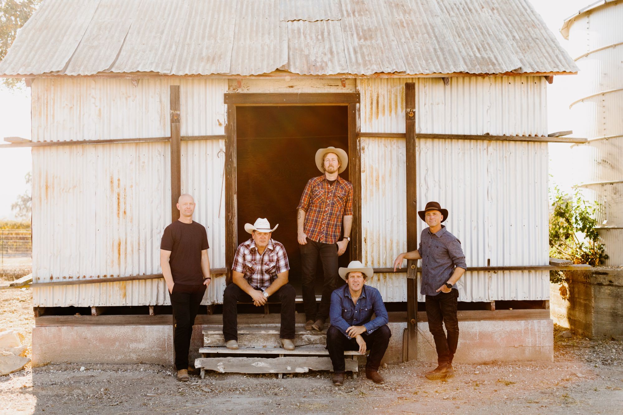 Shawn Clark family band in San Luis obipso posing on an old barn shed at sunset