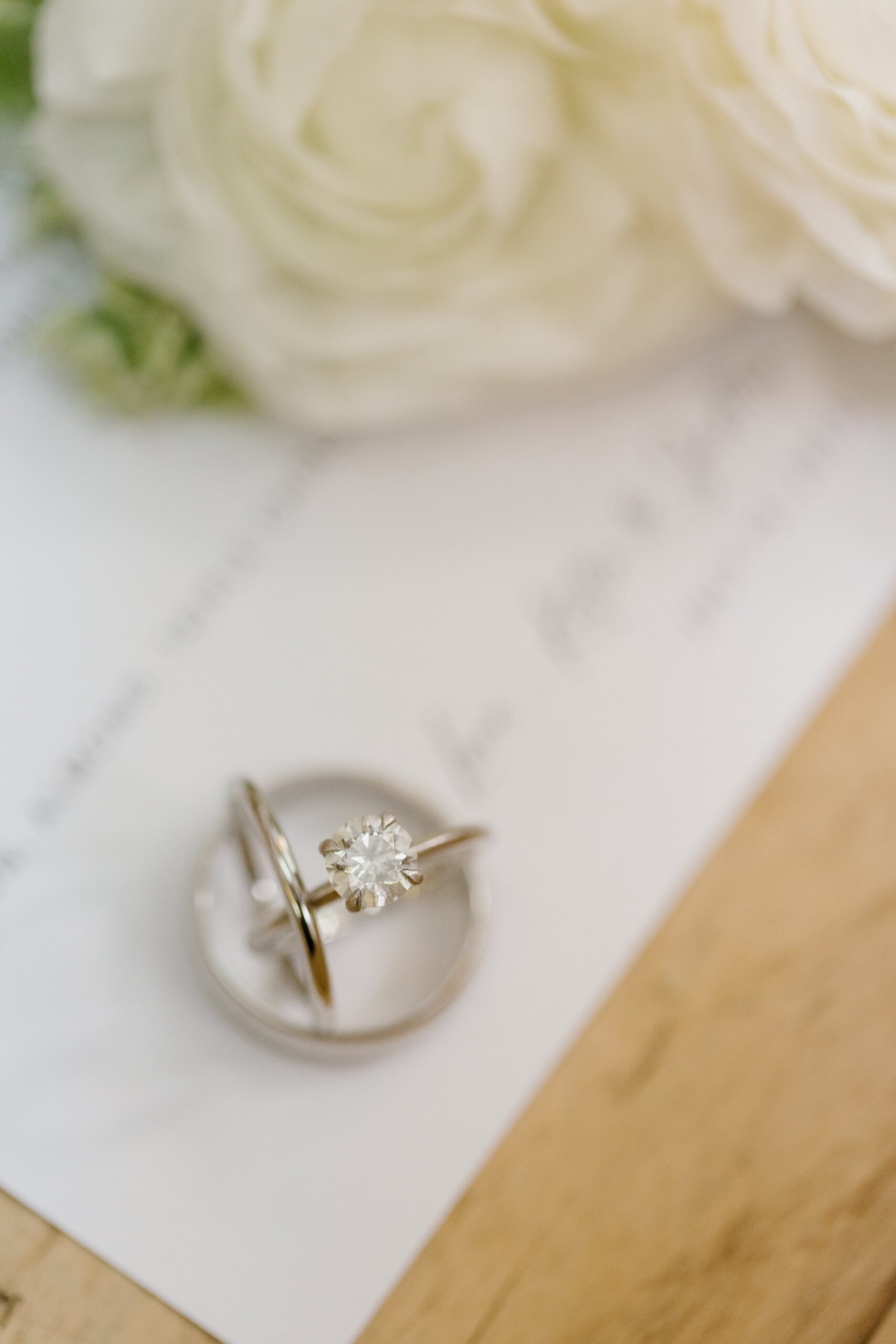 Two wedding rings resting on the side of a white wedding invite to a penny wedding in san luis obispo california