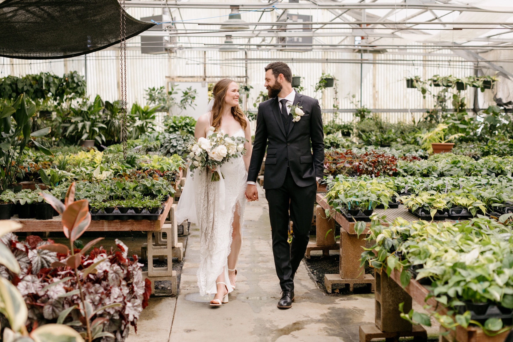 couple walking hand in hand during their portrait session at the cal poly arboretum greenhouses where they had their wedding ceremony, and their wedding reception at the Penny in downtown San Luis Obispo california