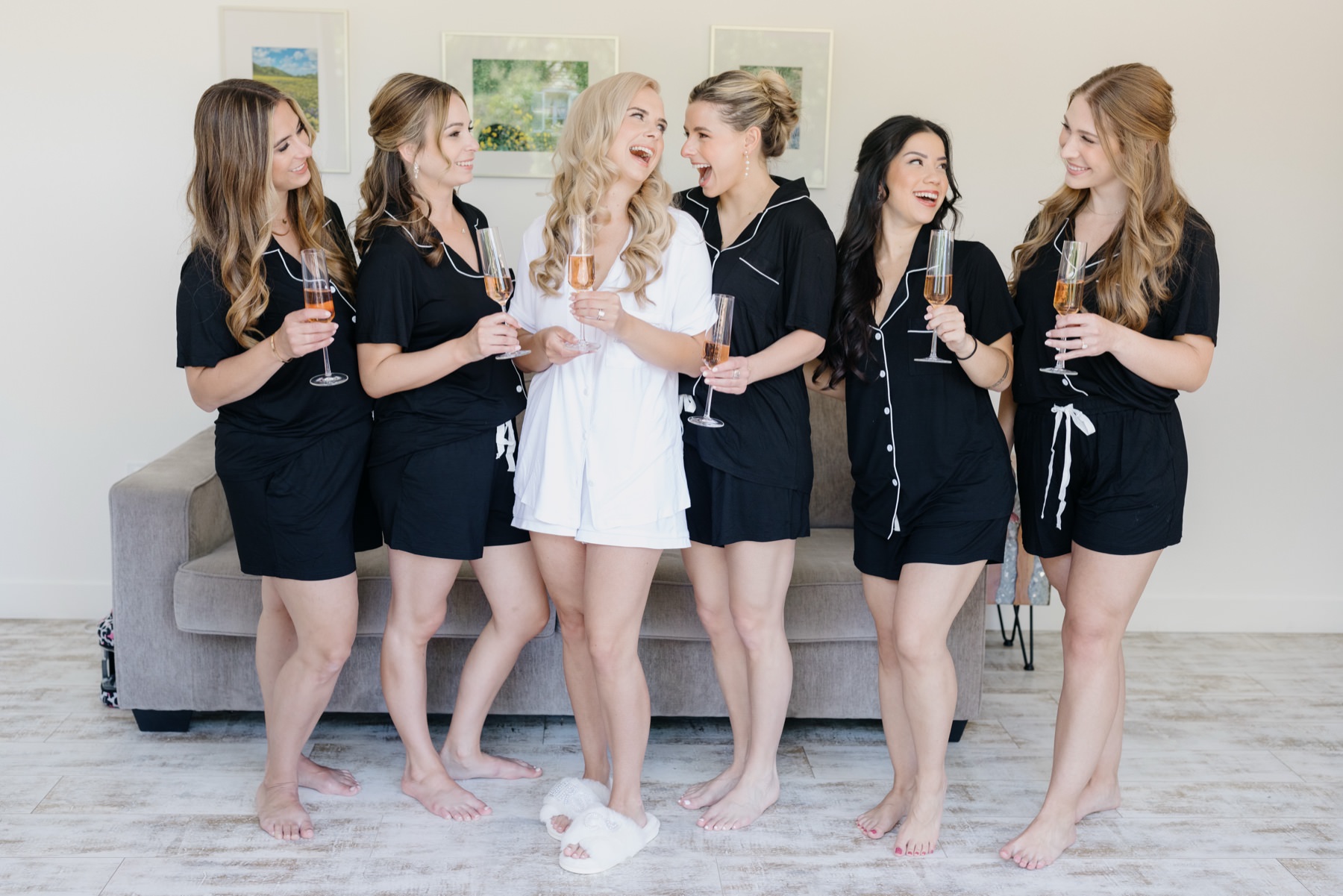 Bridesmaids getting ready at the cass winery inn celebrating with champagne in matching pajamas